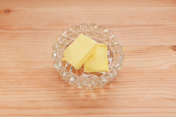 Two pats of butter in a glass dish
