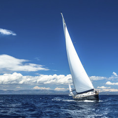 Obraz na płótnie Canvas Yacht sails with beautiful cloudless sky. Luxury yacht.