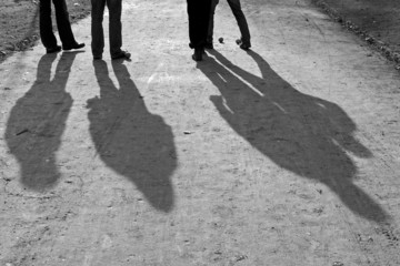 shadow of four people playing boules