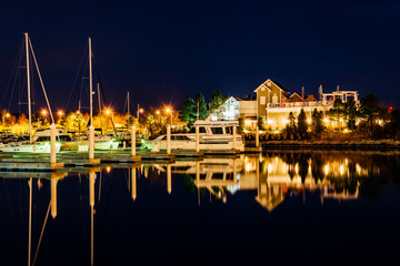 Fototapeta na wymiar Boats reflecting at night at the Bay Bridge Marina in Kent Islan