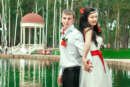 Bride and groom posing in amusement park