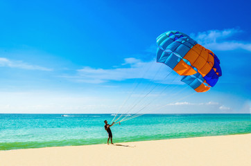 Thai man taking off with parasail on Phuket, Thailand