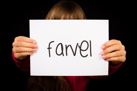 Child holding sign with Danish word Farvel - Bye