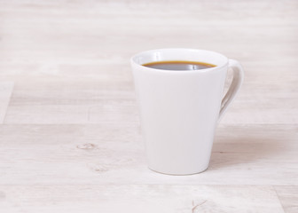 Kaffeetasse auf hellem Holztisch