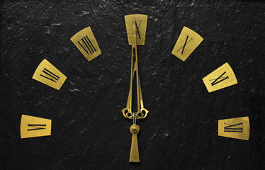 Black clock with golden arms indicating it's about time.