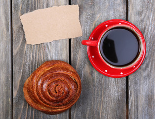 Composition of coffee, fresh bun and paper card