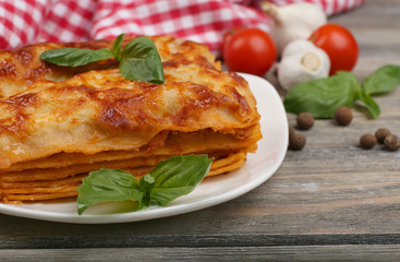 Portion of tasty lasagna on wooden table