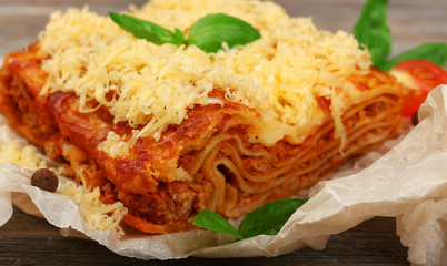 Portion of tasty lasagna on wooden table