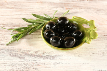 Black olives in small plate with branch