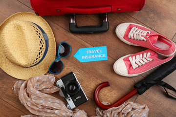 Suitcase and tourist stuff with inscription travel insurance