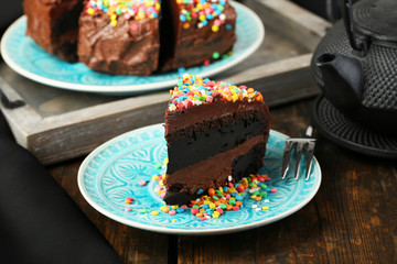Chocolate cake with colorful sweet powder on table close-up