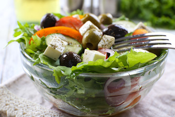 Greek salad in glass dish with fork