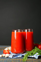 Glasses of tasty tomato juice and fresh tomatoes