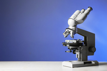 Microscope on table, on blue background