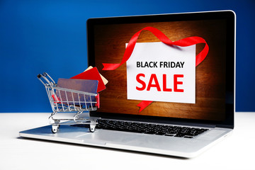 Credit cards in shopping cart and laptop, Black Friday Sale