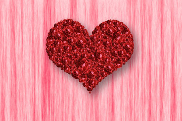 Pile of red rose in heart shape on pink background.