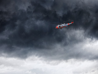 Fototapeta na wymiar Helicopter in Norway seen from below in front dramatic sky