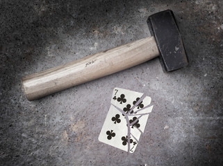 Hammer with a broken card, seven of clubs
