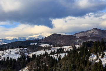 Landscape with snowy mountains under cloudy sky