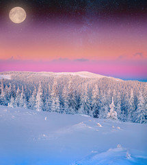Rising moon over frosty winter mountains.