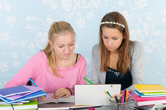 Two Teen Girls Making Homework Together With Digital Tablet