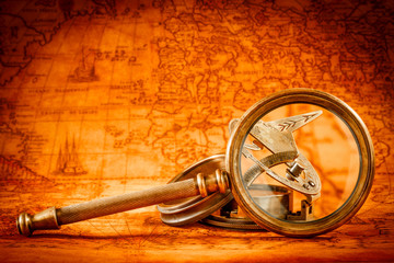 Vintage magnifying glass lies on an ancient world map