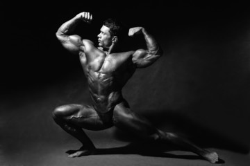 Strong muscular man bodybuilder shows his muscles.