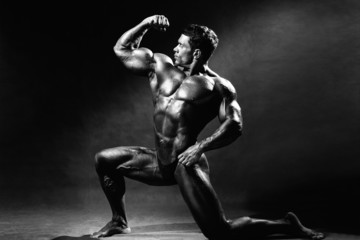 Fototapeta na wymiar Strong muscular man bodybuilder shows his muscles
