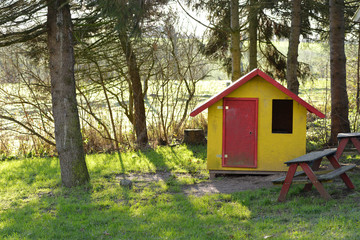 Fototapeta na wymiar Kleines Haus aus Holz mit Picknickbänken