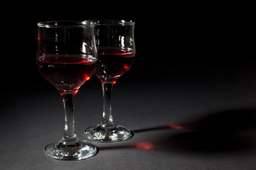 Two Glass Cups Filled With Red Wine Isolated on Black Background
