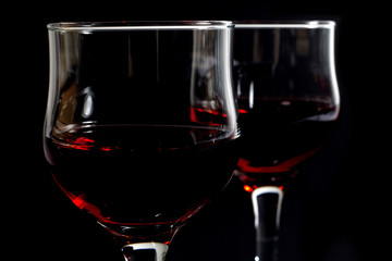 Closeup of Two Wineglasses Filled With Red Wine on Black