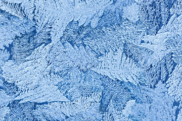 Frozen water on the glass surface. Abstract pattern on winter wi