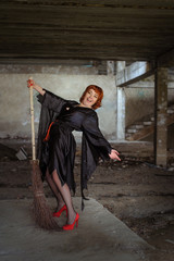 Witch with broom in abandoned building