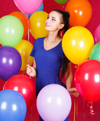 Portrait of a young attractive woman among many bright balloons