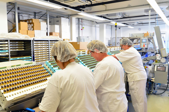 Arbeiterinen verpacken Pralinen in einer Fabrik