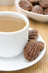 madeleine cookies and a cup of coffee with milk on a plate