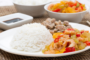 white rice, chicken and vegetables with shrimp on the plate