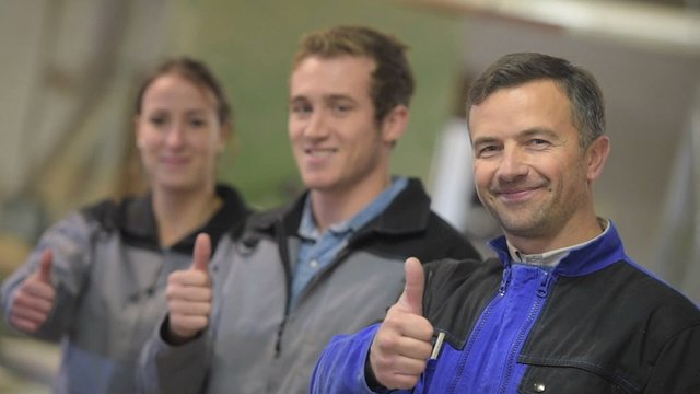 Portrait of carpentry trainer with students in background