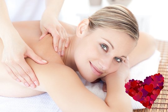 Composite image of smiling woman receiving a back massage