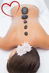 Obraz na płótnie Canvas Beautiful woman receiving stone massage at spa center