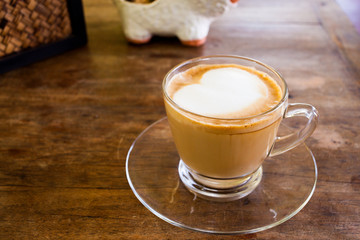 Cup of hot espresso coffee on wooden table.