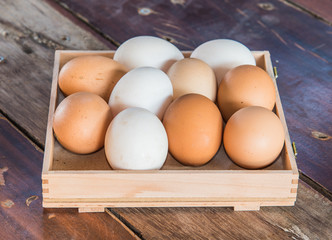 withe and brown color eggs on wood background 