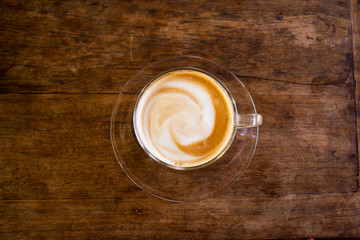Cup of hot espresso coffee on wooden table.