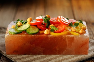 Vegetable salad on pink salt block