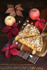 Apple pie, colorful leaves on an old wooden surface