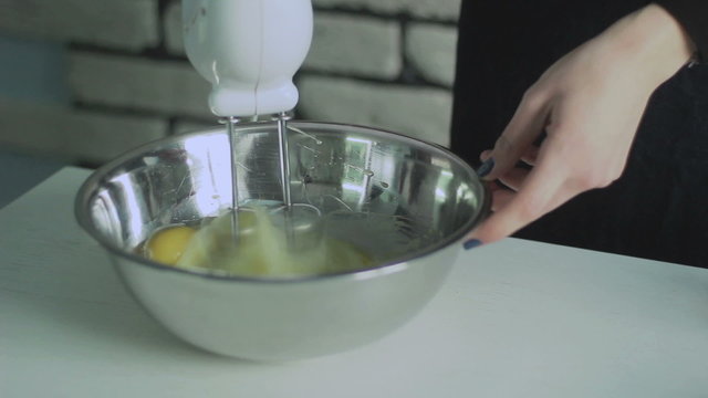 Mixing  egg cream in bowl with motor mixer, baking cake