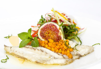 Baked fish with salad on a white background in restaurant
