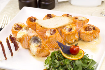 fried fish rolls with herbs on a white plate