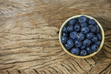 Blueberries in a bowl on a wooden table.