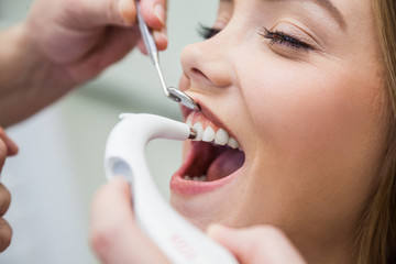 Female Patient Treated With Dental Equipment